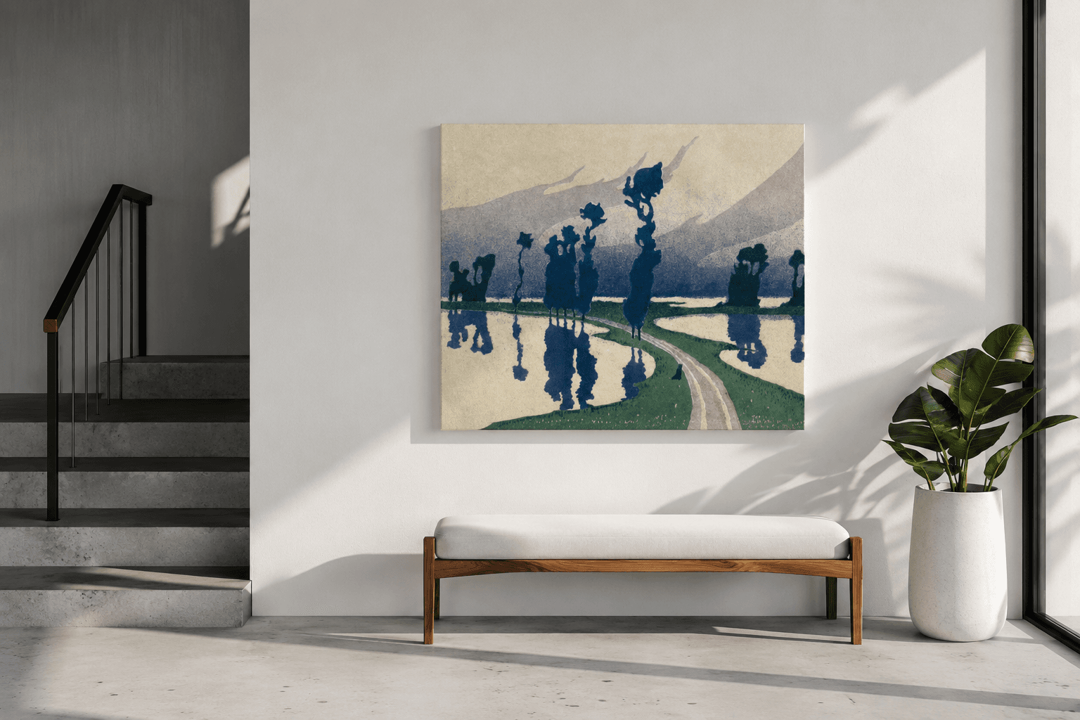 A framed landscape hanging in a light hallway above a bench, with a staircase and a potted plant