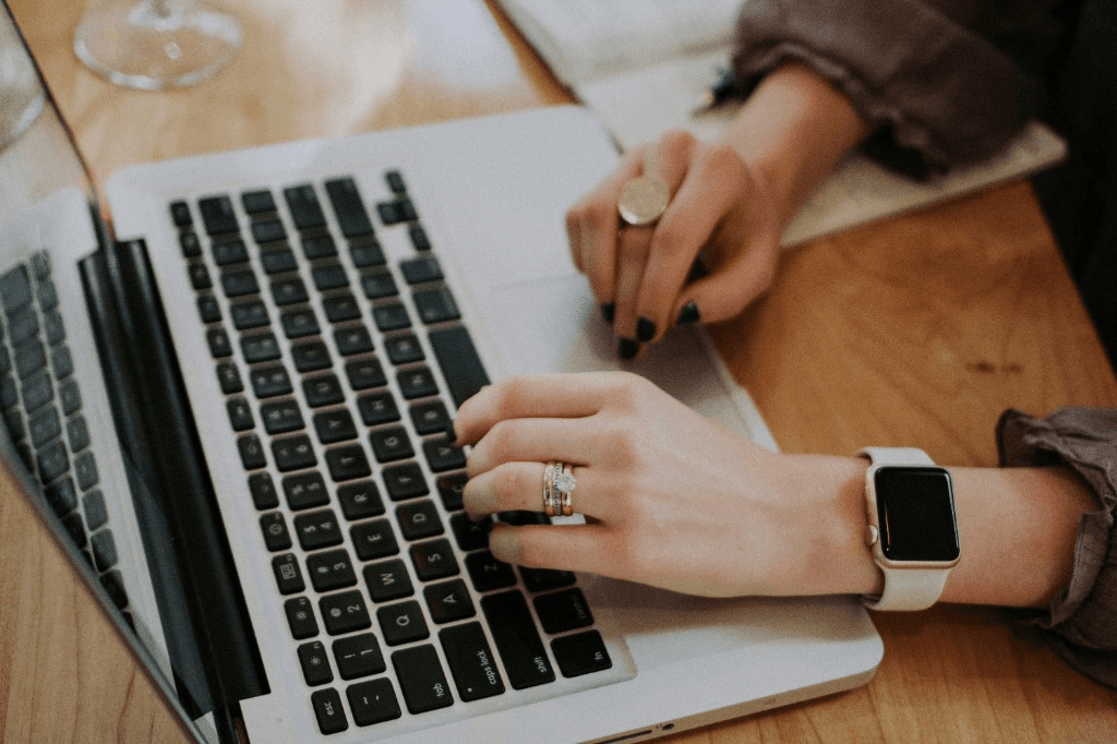 Hands on a laptop keyboard and trackpad